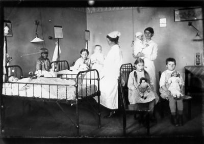 2 kvinnor och 7 barn i sjuksal.
Nyckelord: Docka Säng