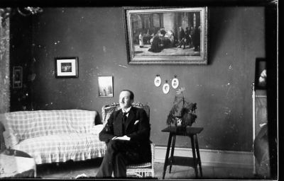 Man sittande i rum.
Nyckelord: Tavla Soffa