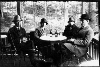 2 män och 2 kvinnor sittande på serveringsveranda.
Nyckelord: Servering Flaska