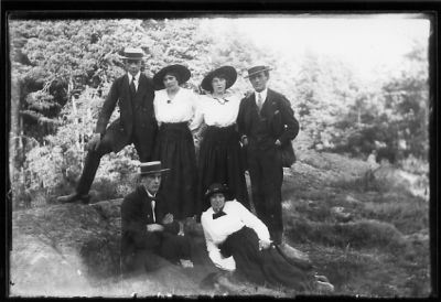 2 män och 2 kvinnor stående och man och kvinna sittande på berg.
Nyckelord: Hatt