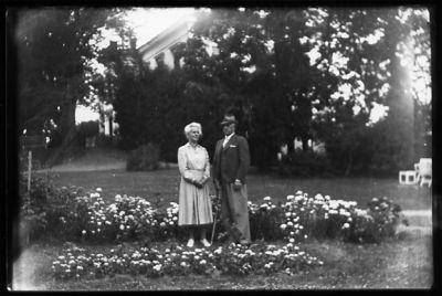 Man och kvinna stående i trädgård.
Nyckelord: Blommor