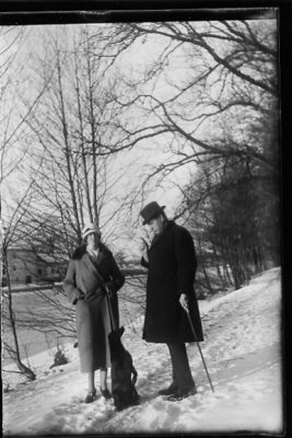 Man, kvinna och hund stående i snön intill vattendrag.
Nyckelord: Hund Vinter
