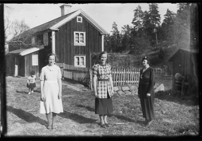3 kvinnor och 1 flicka stående framför byggnad.
Nyckelord: Staket Bostad