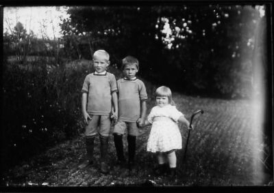 2 pojkar och 1 flicka stående på grusplan.
Nyckelord: Käpp