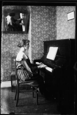 Kvinna sittande vid piano.
Nyckelord: Piano Spegel