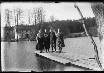 4 kvinnor stående på brygga i vattendrag.
Nyckelord: Brygga