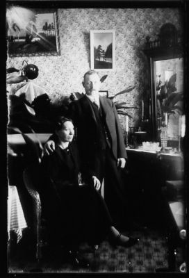 Man stående och kvinna sittande i rum.
Nyckelord: Spegel Tavla