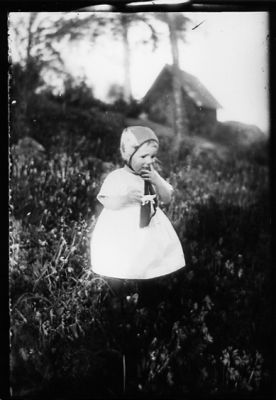 Flicka stående i slänt.
Nyckelord: Mössa