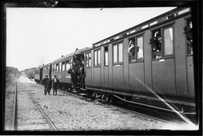 Ett antal män stående vid och på järnvägsvagn.
Nyckelord: Järnvägsvagn Räls
