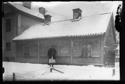 Kvinna stående i snön framför byggnad.
Nyckelord: Vinter