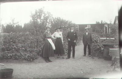 2 män och 2 kvinnor stående i trädgård.
Nyckelord: Trädgård Byggnad
