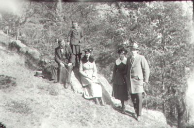 2 män, 2 kvinnor och ett barn sittande eller stående på berg.
Nyckelord: Berg Käpp