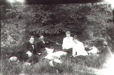 2 män och 2 kvinnor sittande i skogsbacke.
Nyckelord: Skogsbacke Picnic