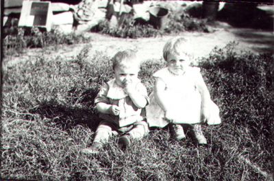 2 barn sittande på gräsmatta.
Nyckelord: Gräsmatta