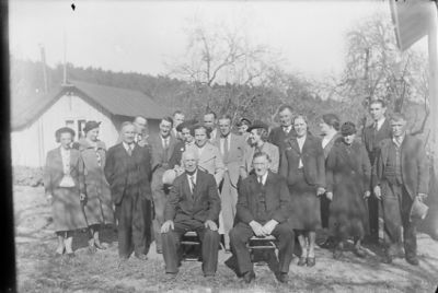 Ett antal personer samlade framför byggnad.
Nyckelord: Trädgård