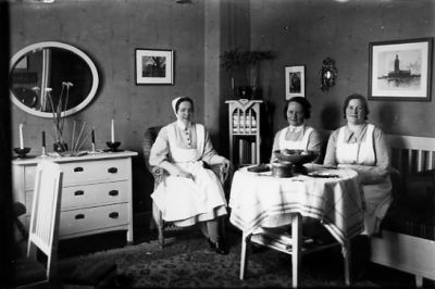 3 kvinnor sittande vid bord i rum.
Nyckelord: Uniform Spegel Tavla Byrå