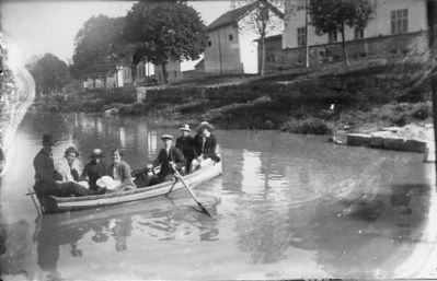 2 män och 5 kvinnor i roddbåt.
Nyckelord: Storån Eka