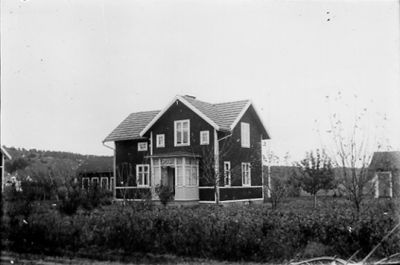 Byggnad i trädgård.
