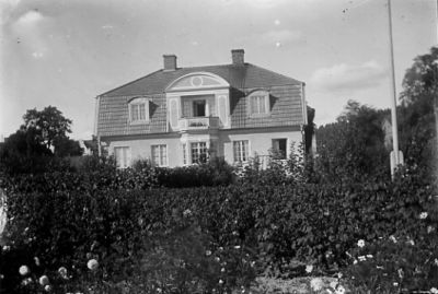 Byggnad i trädgård.
Nyckelord: Trädgård Flaggstång