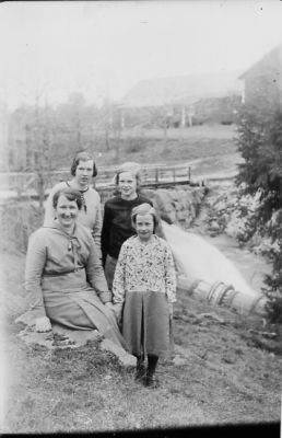 Kvinna och 3 flickor intill vattendrag.
Nyckelord: Bro