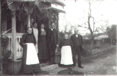 3 män och 4 kvinnor stående på och vid veranda.
Nyckelord: Trappa Veranda Bostad