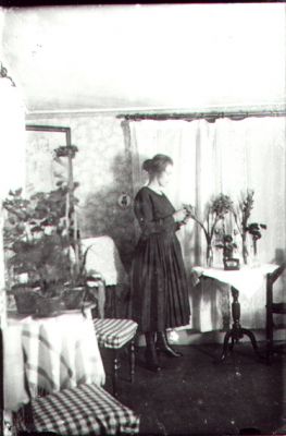 Kvinna stående i rum.
