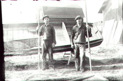 2 män stående framför båt som ligger på land.
Nyckelord: Byggnad