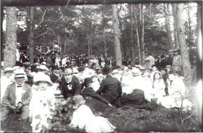 Folksamling i skogsbacke.
Nyckelord: Skogsbacke