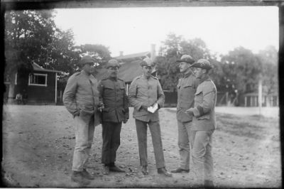 5 militärklädda män stående på plan.
Nyckelord: Uniform Byggnad