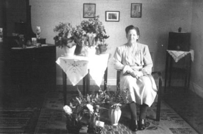 Kvinna sittande i rum med blommor.
Nyckelord: Blommor Tavla