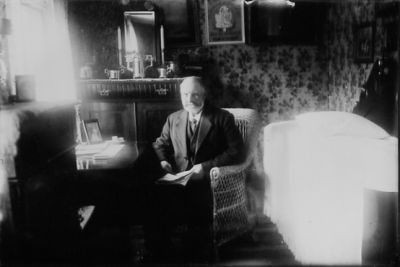 Man sittande i korgstol i rum.
Nyckelord: Tapet Spegel