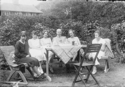 Man och 5 kvinnor sittande vid trädgårdsbord.
Nyckelord: Trädgårdsmöbel Trädgård