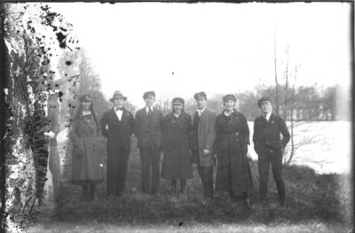 5 män och 3 kvinnor stående intill vattendrag.
