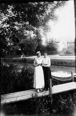 2 kvinnor stående på brygga i vattendrag.
Nyckelord: Brygga Båt