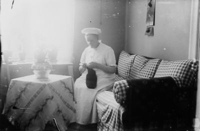 Kvinna sittande i rum.
Nyckelord: Soffa Duk