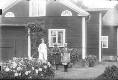 3 kvinnor stående framför byggnad.
Nyckelord: Blommor Grepe Blommor