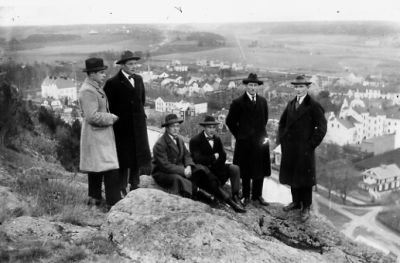 4 män stående och 2 sittande på berg med stadsvy i bakgrunden.
Nyckelord: Utsikt