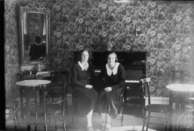 2 kvinnor sittande i rum.
Nyckelord: Piano Tapet Spegel