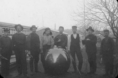 8 män med verktyg stående vid stor kula
Nyckelord: Verktyg Kula