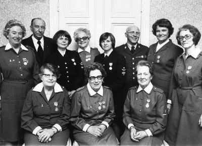 9 kvinnor och 2 män i lokal
Nyckelord: lotta uniform