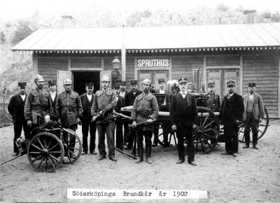 Brandmän med utrustning framför spruthus
Nyckelord: Brandspruta Brandman Uniform Klockkedja