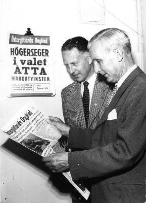 2 män står och läser tidning
Nyckelord: Löpsedel Tidning