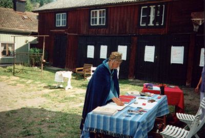 Kvinna utklädd till drottning stående på innergård
Nyckelord: Dräkt