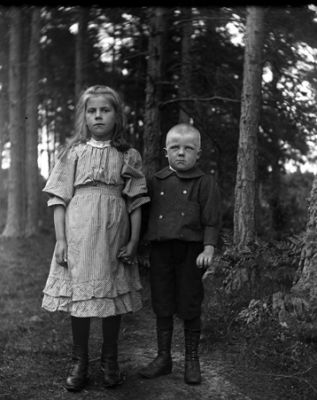 Pojke och flicka stående bland trädstammar
Nyckelord: Barnfotografi