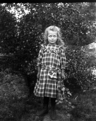 Flicka stående bland lövträd
Nyckelord: Flicka i trädgård