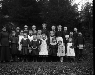 Lärarinna stående ute med sin klass
Nyckelord: Skolklass