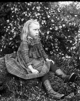 Flicka sittande på liten kulle
Nyckelord: Klänning Kängor