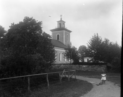 Flicka stående på grusväg vid kyrka
Nyckelord:  Kyrka