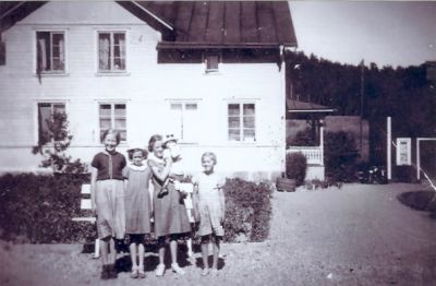 5 barn framför byggnad
