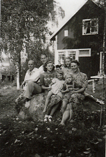Män, kvinnor och barn sittande på stor sten
Nyckelord: Familjeporträtt